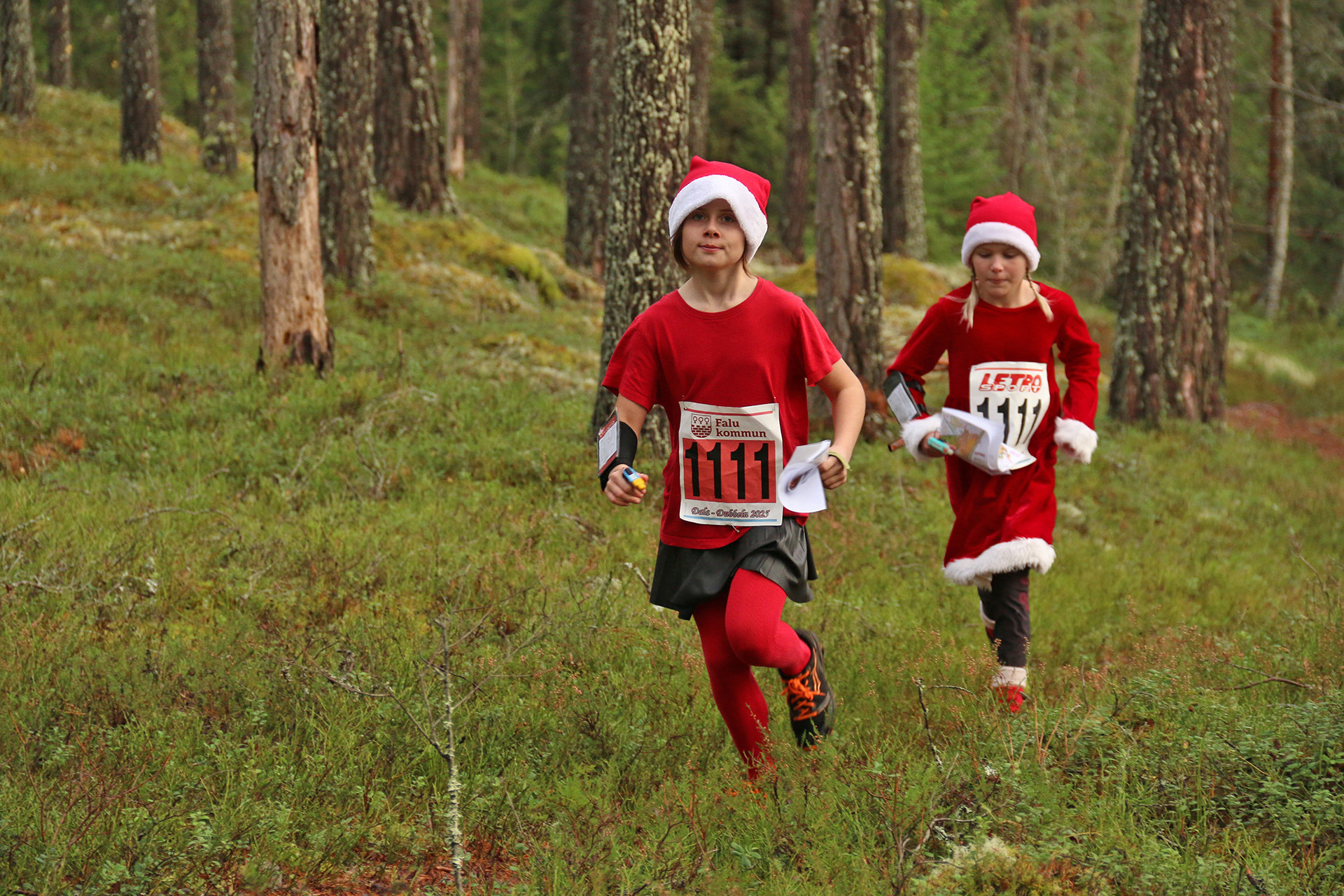 Två "tomtar" springer genom skogen på Daladubbeln 2025.