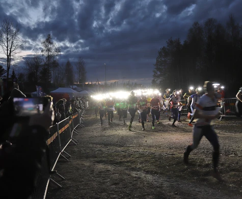 Starten på Tiomilakavlen i Ånnaboda 2022. Förstasträckslöparna rusar fram med sina pannlampor.