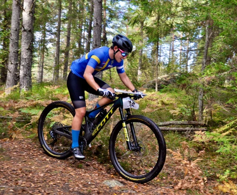 Rasmus Nordgren cyklar på en stig genom skogen i Haninge.