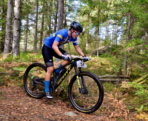 Rasmus Nordgren cyklar på en stig genom skogen i Haninge.