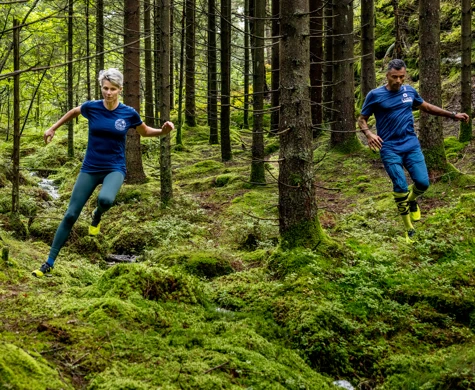 Två löpare med Icebug-skor springer i skogen.
