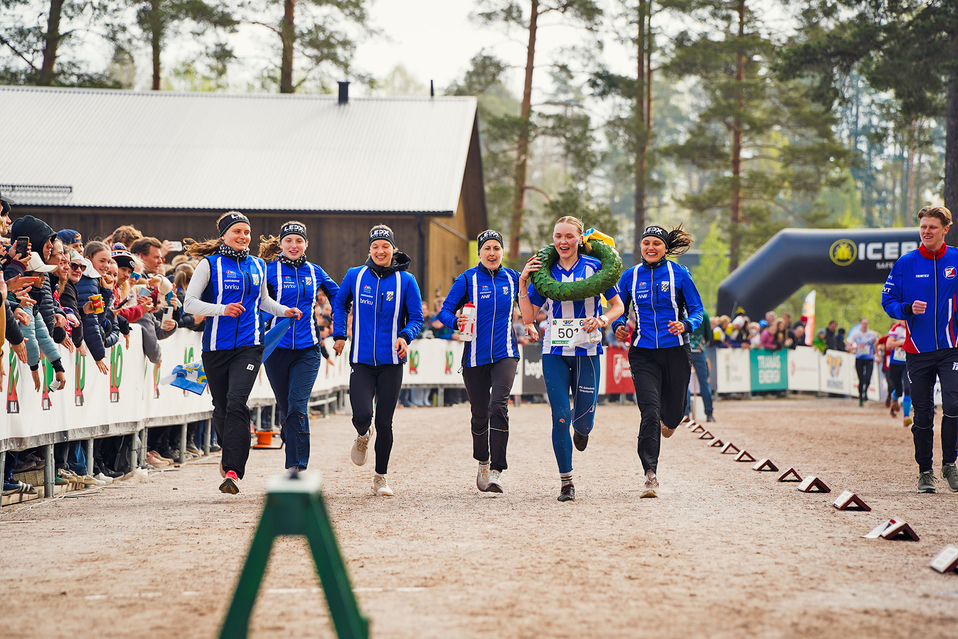 Malin Agervig Kristiansson springer tillsammans med sina lagompisar över mållinjen som segerare i Tiomila 2026. 