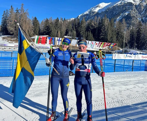 Elin Schagerström och Jonatan Ståhl med svenska flaggan efter segern på mixstafetten vid Student-VM.