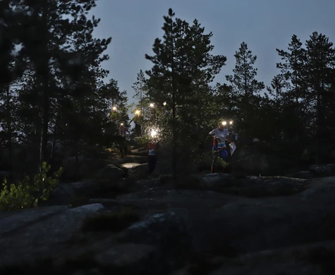 Nattorienterare på rad under Tiomila i Skellefteå 2023.