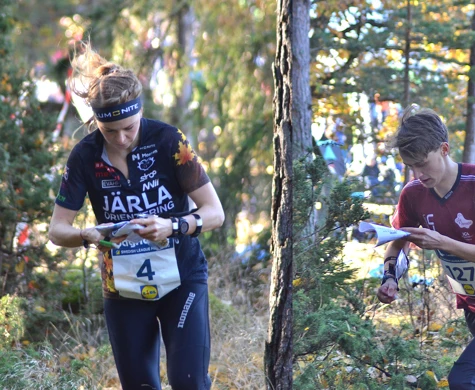 Karolin Ohlsson och August Mollén springer i skogen under koncentrerad kartläsning.